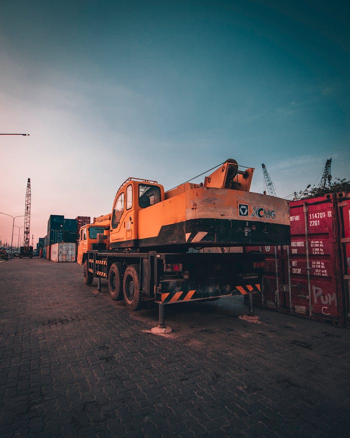 A bustling port with heavy machinery and containers during sunset in Tanjung Priok, Jakarta.